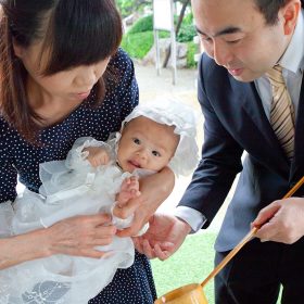 琴平神社で赤ちゃんにお手水をするパパとママ