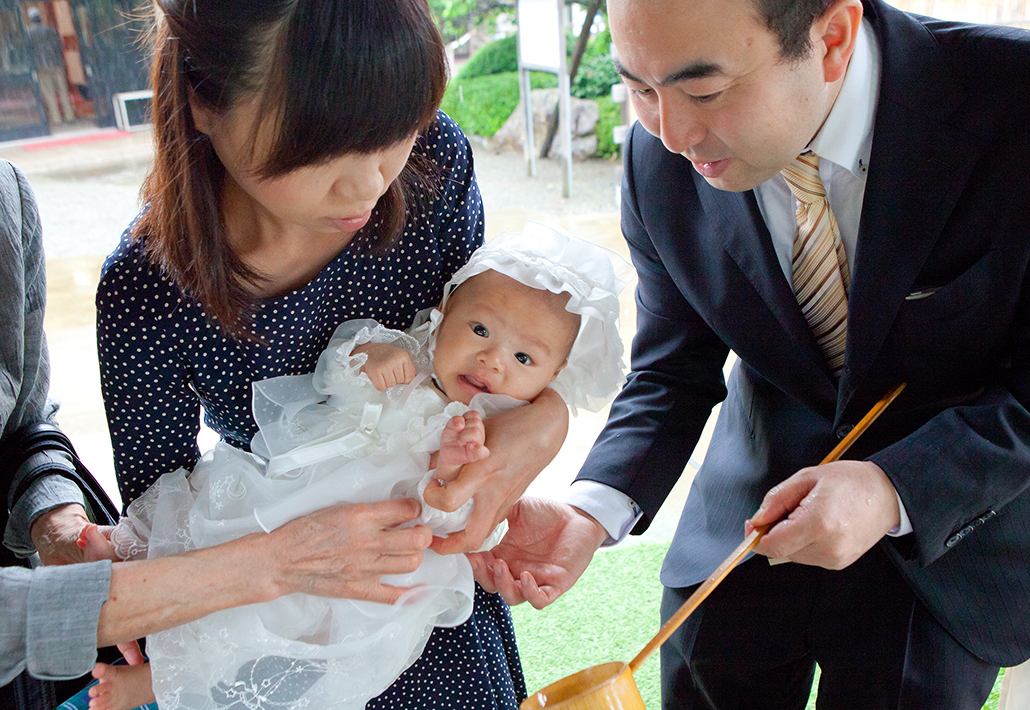 琴平神社で赤ちゃんにお手水をするパパとママ