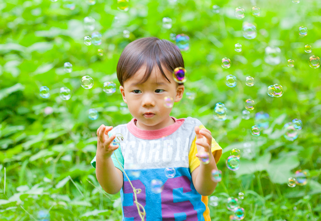 シャボン玉遊びを楽しむ子供の写真