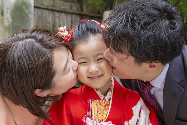 七歳七五三記念の女の子にキスするご両親の写真